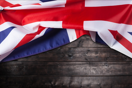 Closeup image of UK, British flag, Union Jack over wooden backgroundの写真素材