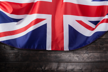 Closeup image of UK, British flag, Union Jack over wooden backgroundの写真素材