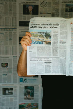 Barcelona, Spain, April 5, 2020: reading a newspaper in front of a news wall. Over informed. 3のeditorial素材