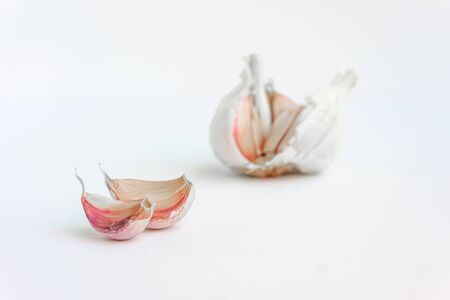 Detail of two raw garlic cloves isolated on white. Close up view.の写真素材