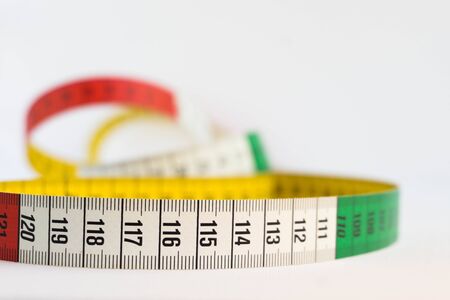 Detail of a colorful measuring tape isolated on white. Diet and measure concept.