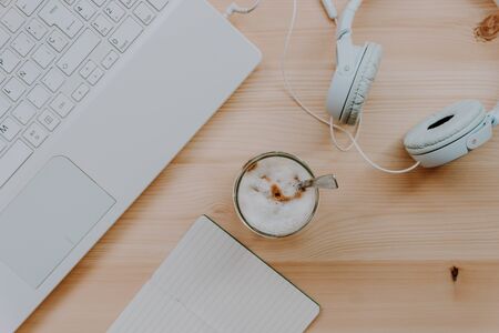 Home office. Quiet workspace with coffee, laptop, headphones and a notebook. Work away. Relax and disconnection moment with chill music. Top view.の写真素材