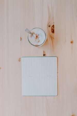 Work time concept. Coffee and a notebook on a natural pine table. Quiet workspace. Inspiration. Top view.の写真素材