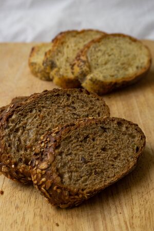 Bread slices on a wooden table. Integral brads. Corn bread. Selective focus. Vertical photo.