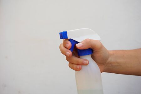 Hand holding a disinfectant sprayer bottle isolated on white. Cleaning covid and disinfectant concept.の写真素材