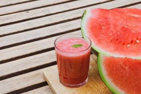 Summer watermelon juice with min on a wooden table with watermelon fruit. Summer food and drinks concept.の写真素材