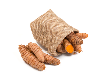Raw turmeric root in burlap sack isolated on white backgroundの写真素材