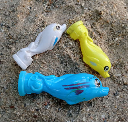 Colored toy fish on a beachの写真素材