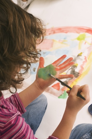 young girl enjoys painting handの写真素材