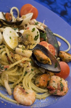 spaghetti with seafood on blue dishの写真素材