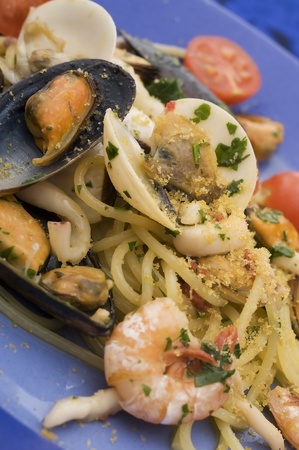 spaghetti with seafood on blue dishの写真素材