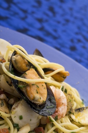 spaghetti with seafood on blue dishの写真素材