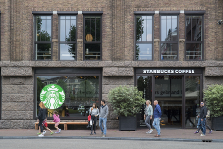 people walking in front of the Starbucks coffee place at the Rembrandplein August 13th 2016, Amsterdam, the Netherlandsのeditorial素材