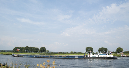 Freight ship on the Meuse River at Cuijk, Netherlands 20 July 2016のeditorial素材