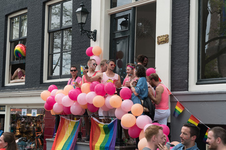 Amsterdam, August 5 2017: Citizens looking at the 2017 Canal parade from their house on the Prinsengracht in the center of Amsterdamのeditorial素材