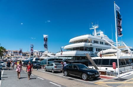 Puerto Banus, Spain, June 28 2017: tourist walking and looking at big luxury yachts and cars in the harbourのeditorial素材