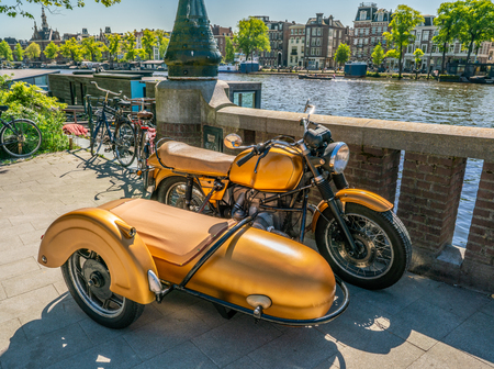 Amsterdam, May 7 2018 - resotred old motorcycle with sidecar parked at the riverside of the river Amstelのeditorial素材