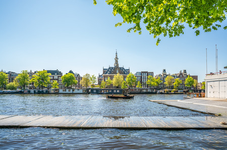 Amsterdam, May 7 2018 - Small boat with passengers sailing on the river Amstel with view on the other sideのeditorial素材