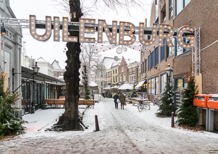 Den Bosch, The Netherlands, December 10th 2017: People entering a Chistmas decorated and snow covered Uilenburg street in the center.のeditorial素材
