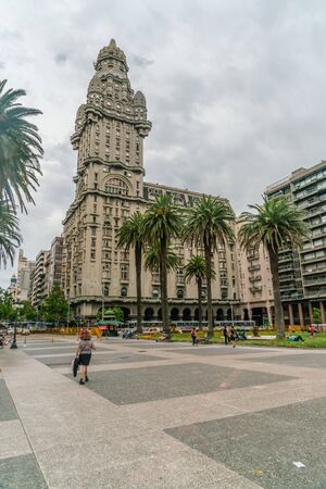 tourists passing the Independance square (Plaza Indepencia) with in the background the famous Salvo Palace (Palacio Salvo), Montevideo, Uruguay, January 25th 2019のeditorial素材
