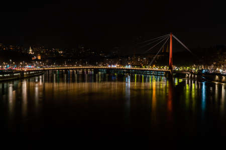 Lyon, France 3rd January 2020 - People srossing the Saone River on the Passerelle du Palais de Justice (Law Courts Walkway) bridge at nightのeditorial素材