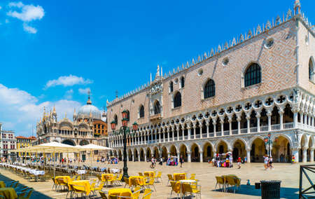 Venice, Italy - June 29th 2020 - very little tourists crossing the San Marco square and passing the empty terraces with the Saint Mark's Basilica (Basilica di San Marco) and the Doge's Palace (Palazzo Ducale) on a sunny Corona day in summerのeditorial素材