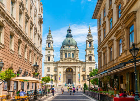 Budapest, Hungary - June 26th 2020 - Exterior of the grand church, basilica, seen from the Zrinyi street during Corona time on a sunny day with some tourists visiting the square and restaurantsのeditorial素材