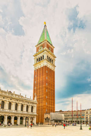 Venice, Italy - June 29th 2020 - very little tourists crossing the San Marco square with the St Mark's Campanile tower (Loggetta del Sansovino) on a sunny Corona day in summerのeditorial素材