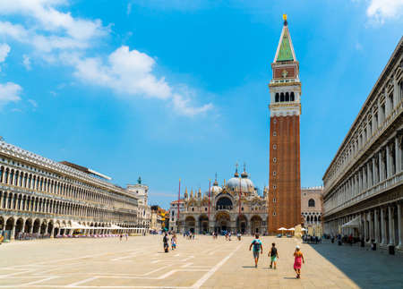 Venice, Italy - June 29th 2020 - very little tourists crossing the San Marco square with the St Mark's Campanile tower (Loggetta del Sansovino) and the Saint Mark's Basilica (Basilica di San Marco) on a sunny Corona day in summerのeditorial素材