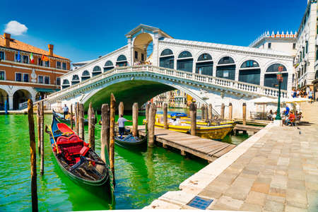 Venice, Italy - june 29th 2020 - very little tourists crossing the Grand Canal over the Rialto bridge (Ponte di Rialto) with workless gondolier on a sunny Corona day in summerのeditorial素材