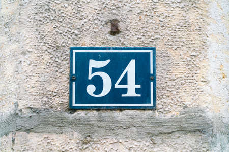 House number 5 White on blue on an old metal limestone wall of a authentic Franch houseの写真素材