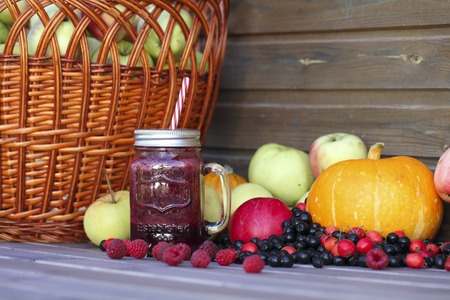 Berry smoothie on rustic wooden background witth baasket. Autumn Harvest Festivalの写真素材