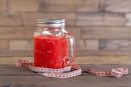 Red smoothie and centimeter on old woodの写真素材