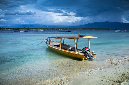 traditional style tourist boat in the shallow waters of gili trawangan lombok indonesiaのeditorial素材