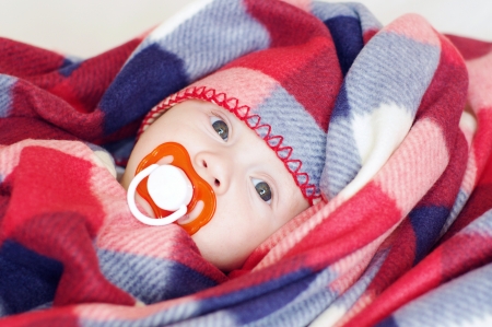 The four-months baby covered by a checkered plaid の写真素材