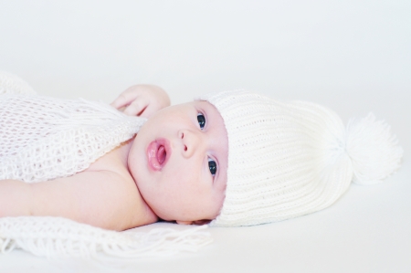 Baby in a white knitted hat age of 1 month