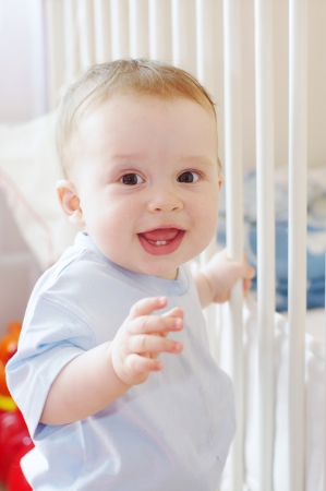 baby stands by white bedの写真素材