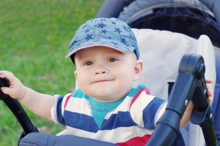 baby boy on baby carriage in summer