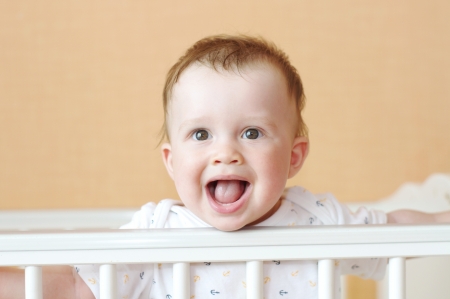 happy baby age of 9 months in white bed の写真素材