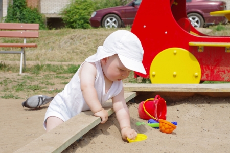 baby plays with sand on playgroundの写真素材