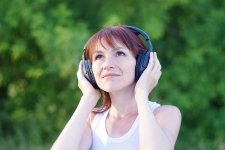 happy woman outdoors in wireless headsetの写真素材