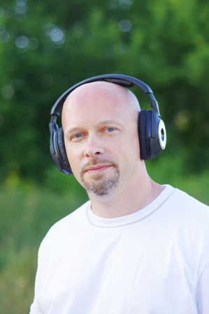 man listening music outdoors in wireless headsetの写真素材