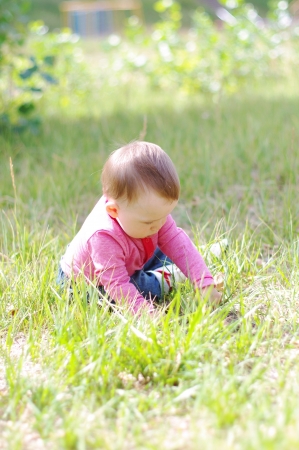 baby playing on grass in summerの写真素材