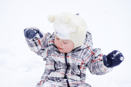 portrait of 1 year baby playing in snow in winterの写真素材