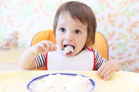 lovely baby boy eating quark by himselfの写真素材