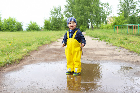 lovely happy baby standing in puddleの写真素材