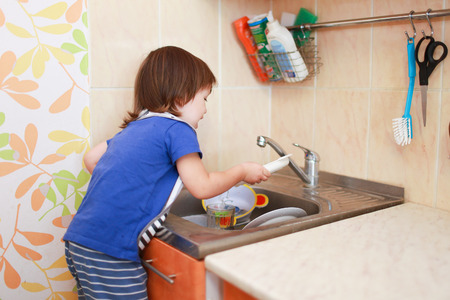 lovely 2 years boy washing dishesの写真素材