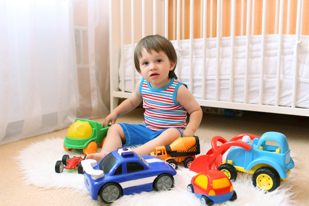lovely baby boy playing cars at homeの写真素材