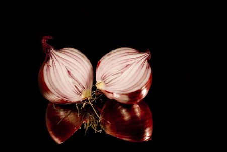 two sliced onions on a black mirrorの写真素材