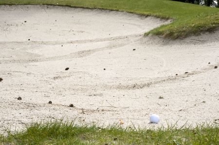 golf ball in the sandbank at the golf courseの写真素材